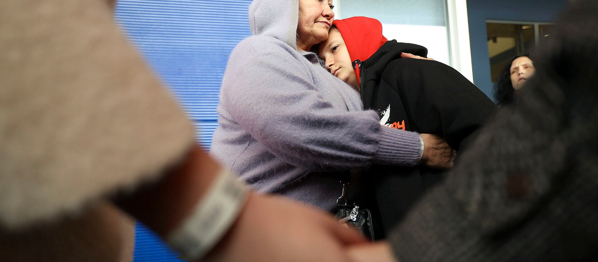 Ukrainian refugee Valentina Chukhno hugs her grandson, Zhan, as Chukhno’s daughter and granddaughter hold hands.
