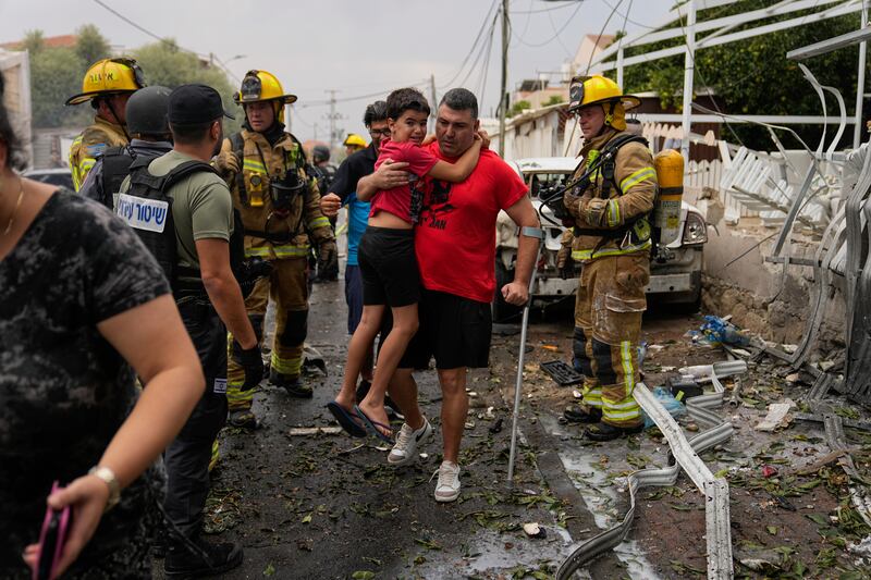 Israelis evacuate a site struck by a rocket fired from the Gaza Strip, in Ashkelon, southern Israel, on Oct. 9, 2023.