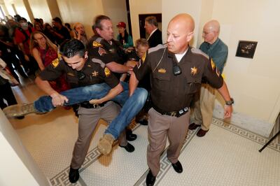 Utah Highway Patrol troopers remove a protester after he and several others disrupted a Utah Inland Port Authority board meeting at the Capitol in Salt Lake City on Wednesday, June 5, 2019.