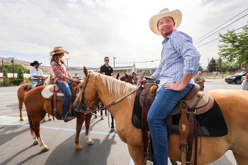 Utah first lady Abby Cox, left, and her husband, Gov. Spencer Cox, sit on their horses at West High School in Salt Lake City.