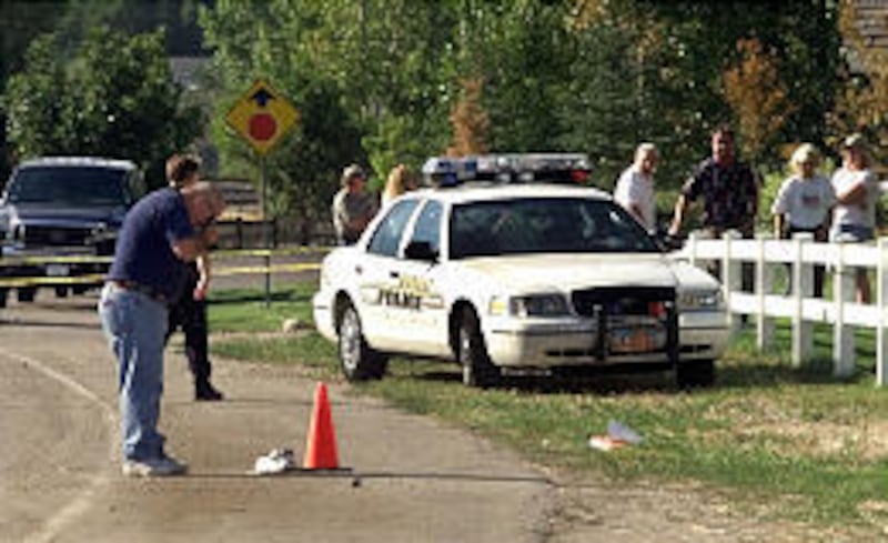 A Murray police officer photographs evidence after a street racing accident on Aug. 31, 2001, in which 13-year-old Craig Warburton was killed while walking home from school along Murray Parkway. The teenager's mother testified at the Capitol on Wednesday.