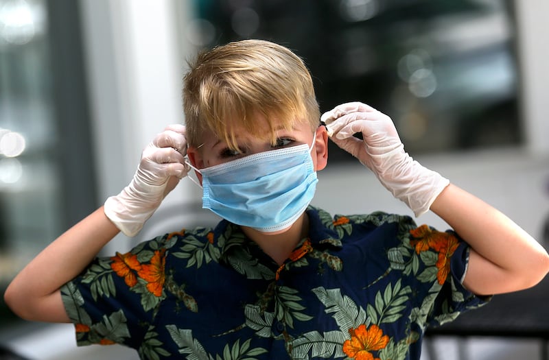 Barret Pritchard, 8, puts on a mask while working at a lemonade stand with his sister in Provo.