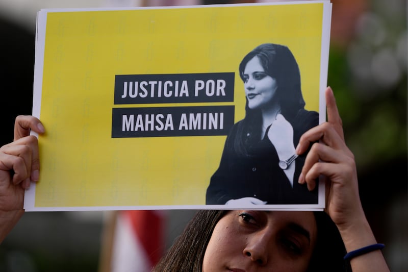 A woman holds a sign that reads in Spanish “Justice for Mahsa Amini” as she protests in front of the Iranian embassy in Buenos Aires, Argentina,