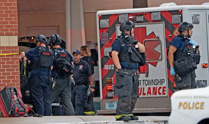 Members of law enforcement wait outside after a deadly shooting on Sunday at the Greenwood Park Mall, in Greenwood, Ind.