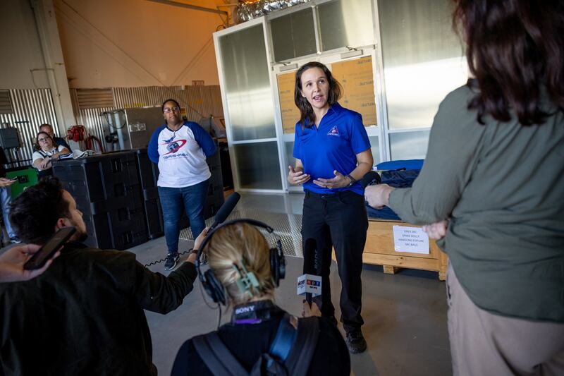 Kimberly Allums, OSIRIS-REx curation project lead, back left, and Nicole Lunning, lead sample curator for OSIRIS-REx, talk to journalists outside a cleanroom at Dugway Proving Grounds on Thursday.