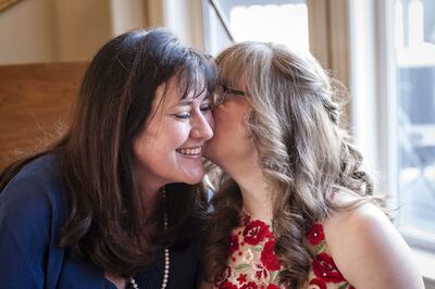 Emily Arthur, right, kisses her mom, Julie Arthur, before going to her prom on Saturday, April 14, 2018.