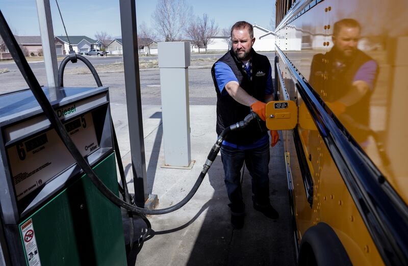 Shaun Adams, assistant director of transportation for Tooele County School District, pumps gas into a school bus at a state fuel center in Tooele.
