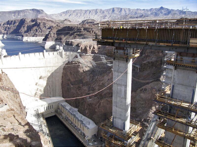 A towering column that will support a bridge replacing the roadway over the Hoover Dam is seen next to the dam.