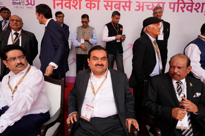 Industrialist Gautam Adani sits for a group photograph.
