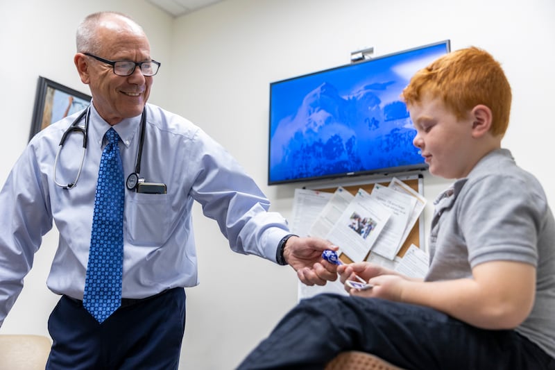 Dr. David Cope hands Kason Deslaurier a lollipop after an appointment at Cope Family Medicine in Bountiful.