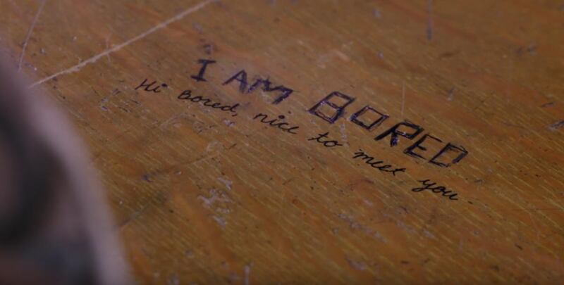 In a new video bringing awareness to the warning signs of school shootings, a high school student scrawls a message on a desk at the school's library, hoping to connect with a fellow student.