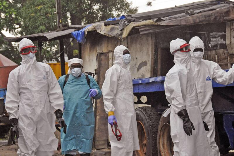 Liberian health workers outside a home of a man that they believed died from the Ebola virus in Monrovia, Liberia, Friday, Aug. 29, 2014. The Ebola outbreak in West Africa eventually could exceed 20,000 cases, more than six times as many as are now known