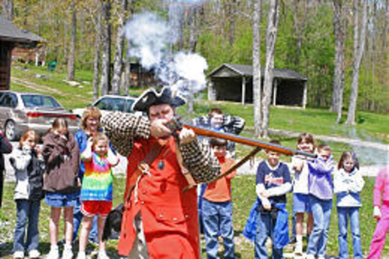 Ryan Cuba, dressed as a French and Indian War colonial soldier, fires a Brown Bess flintlock musket May 18 at the 4-H Camp in Bittinger, Md. Living historians marked the 250th anniversary of British Maj. Gen. Edward Braddock's 110-mile march through the M