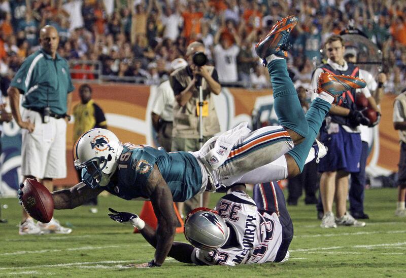 FILE - In this Sept. 12, 2011, file photo, Miami Dolphins wide receiver Brandon Marshall (19) stretches near the goal line as New England Patriots defensive back Devin McCourty (32) defends during the second half of an NFL football game, in Miami. Marshal