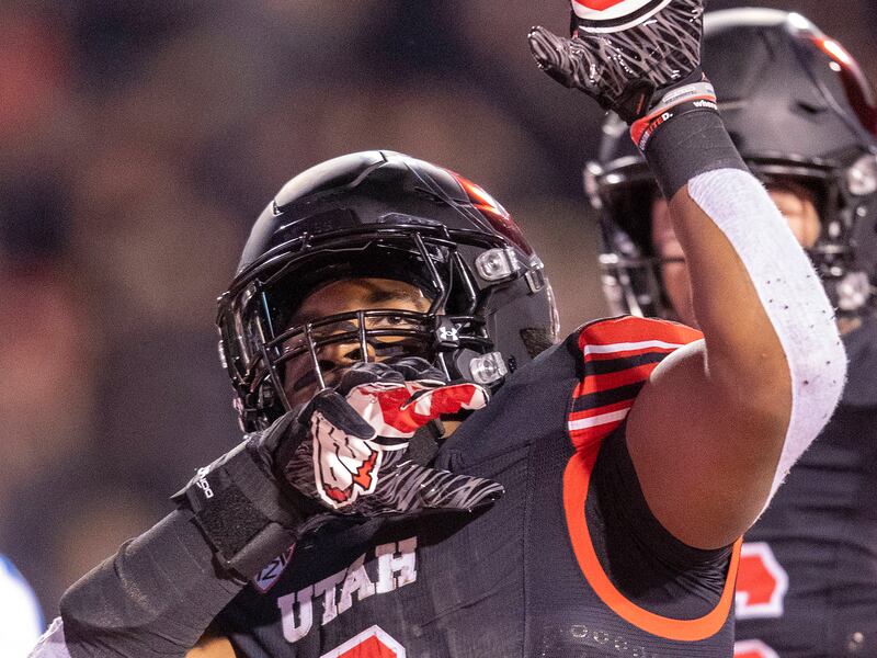 Utah Utes running back Tavion Thomas raises his arm in celebration