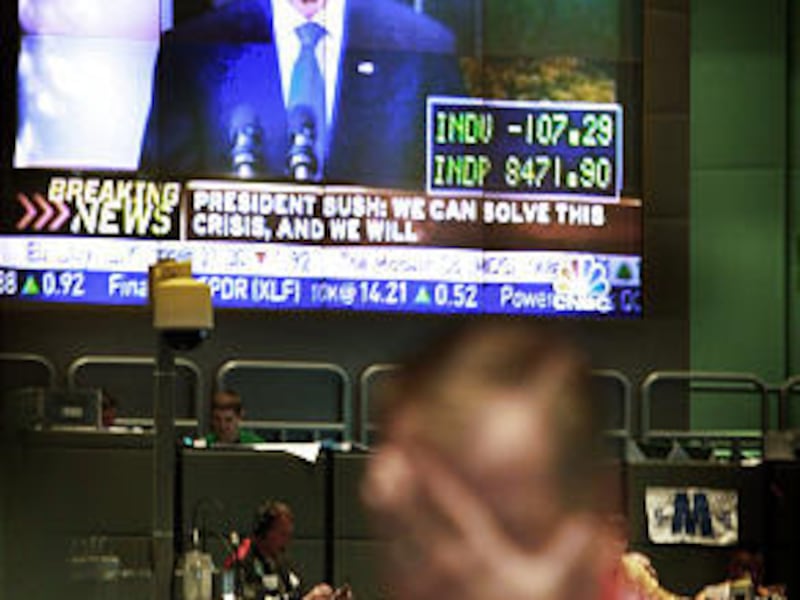 A trader in the Dow Jones Industrial Average stock index futures pit at the Chicago Board of Trade reacts to trading as a monitor above the trading floor broadcasts U.S. President George W. President Bush addressing the nation about the financial crisis.