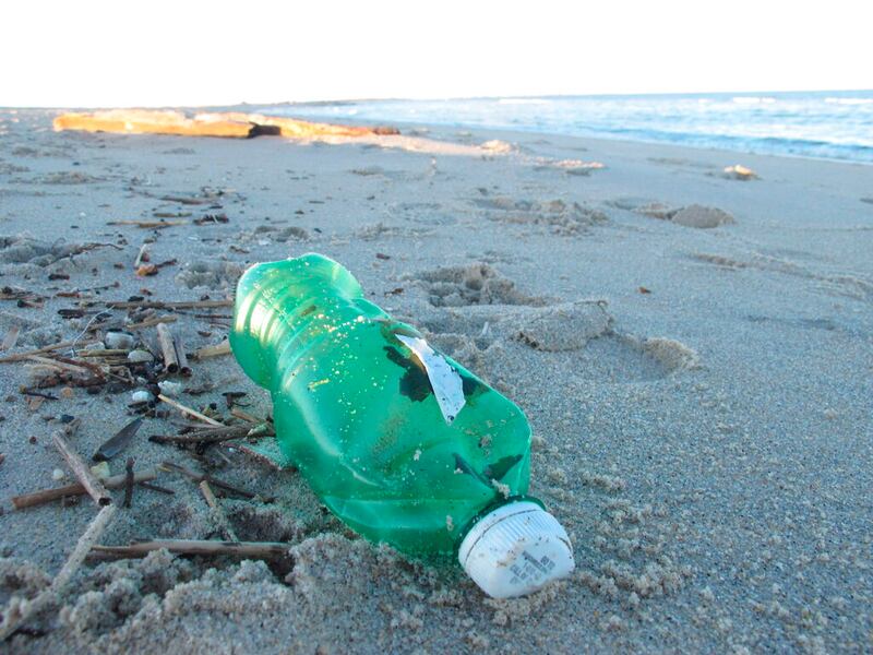 A beverage bottle on the sand in Sandy Hook, N.J.