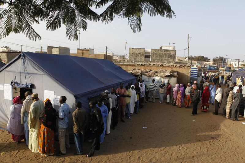 Voters wait in line to cast their votes outside tents erected to serve as polling stations, in the Guediawaye neighborhood of Dakar, Senegal Sunday, March 25, 2012.