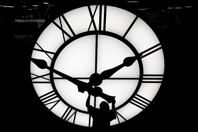Electric Time technician Dan LaMoore puts a clock hand onto a 1000-lb., 12-foot diameter clock constructed for a resort in Vietnam.