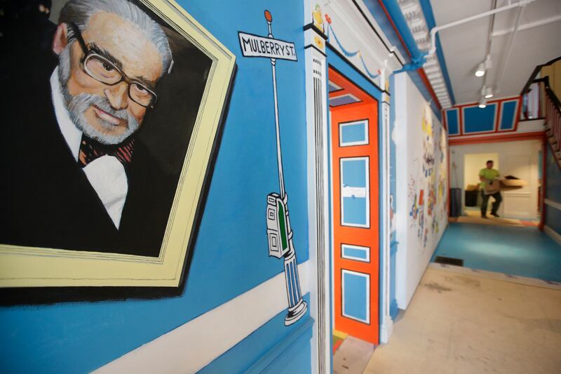 In this May 4, 2017, photo a mural that features Theodor Seuss Geisel, left, also know by his pen name Dr. Seuss, rests on a wall near an entrance at The Amazing World of Dr. Seuss Museum, in Springfield, Mass. (AP Photo/Steven Senne)