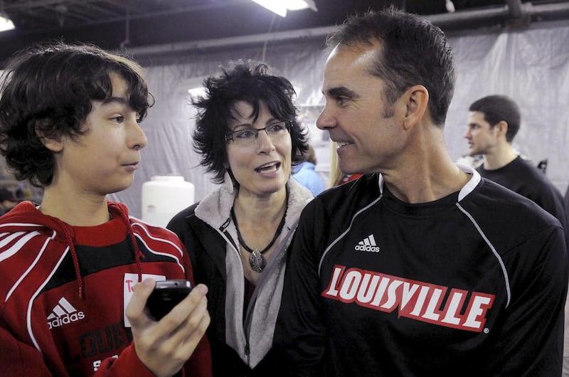 In a Feb. 26, 2011 photo, University of Louisville men's soccer head coach Ken Lolla, right, talks with wife Tina Lolla, center, and son Tyler, 13, about an interview video Tyler had been shooting at Edge Outreach. While Louisville will still play a handf