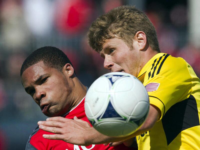 FILE - In this March 31, 2012 file photo, Columbus Crew midfielder Kirk Urso, right, battles for the ball with Toronto FC forward Ryan Johnson during first half MLS soccer action in Toronto. Urso has died at an Ohio hospital. Franklin County Coroner Dr. J