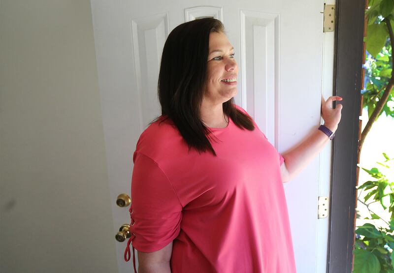 Lori Lloyd looks out of the front door of her home in Midvale, Utah, on Saturday, June 15, 2019. Lloyd is a mother of three and a former meth addict who was incarcerated from 2007-2009.