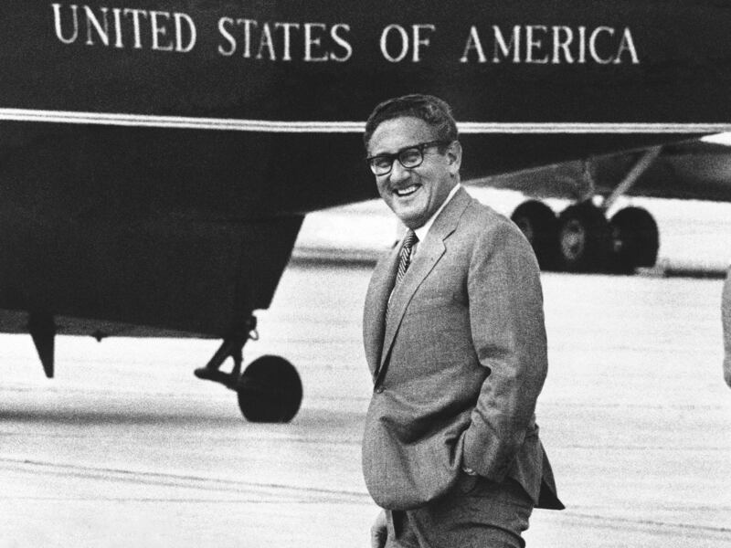 Henry Kissinger smiles as he walks to a helicopter at Andrews Air Force Base near Washington.