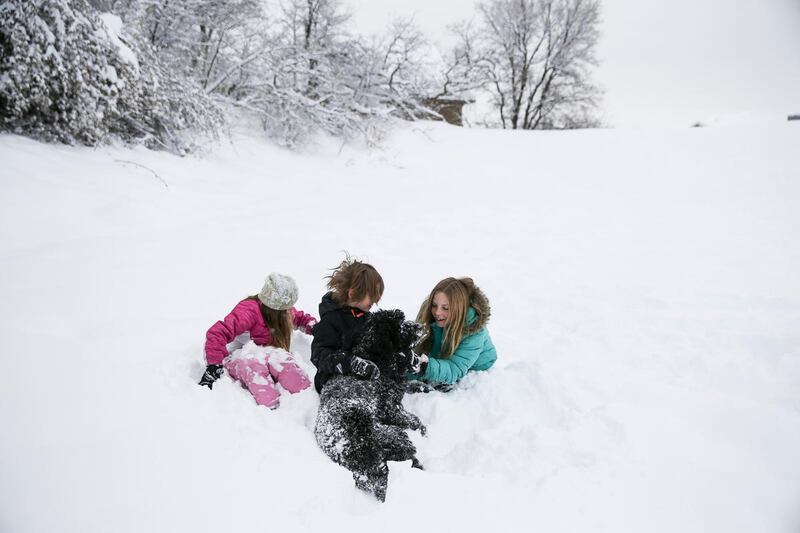 FILE "” Eva, 9, Leo, 6, and Bronwen Southworth, 11, who are homeschooled, play with their dog, Luna, in the snow outside their home in Bountiful after a snowstorm on Thursday, Jan. 05, 2017. Officials made the call to cancel schools Friday for Cache
