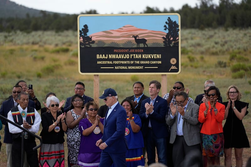 President Joe Biden, center left, takes the stage to speak at the Red Butte Airfield on Aug. 8, 2023, in Tusayan, Ariz.