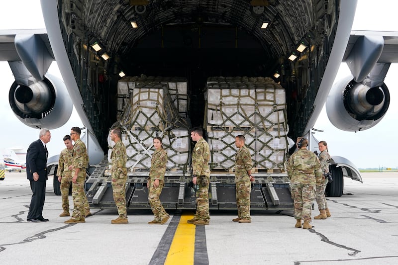 Agriculture Secretary Tom Vilsack greets crew members of a C-17 that delivered a plane load of baby formula.