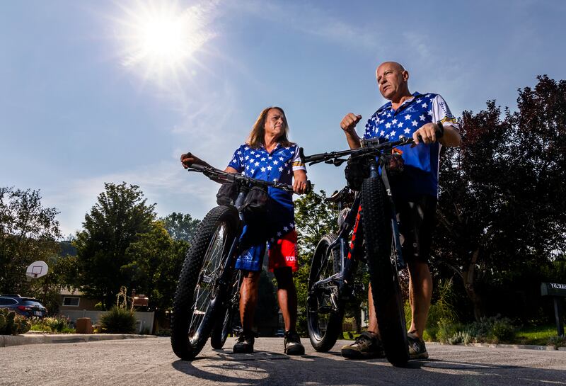 Lorri, left and Dean Zenoni pose for a photo on a street near their home in Sandy, Utah.