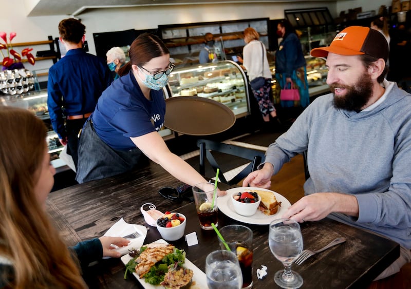 Eloise Schmitt serves lunch to Emma Larsen and her father, Shawn, at Gourmandise in Salt Lake City on April 8, 2021.