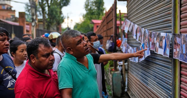 Photo: deseret.com People look at photographs of people killed in flash floods displayed outside a government hospital to help relatives