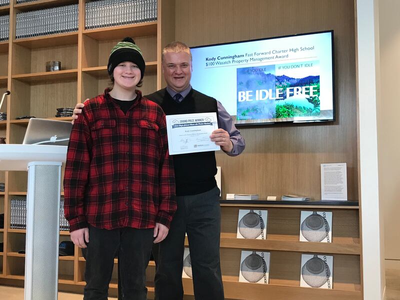 Kody Cunningham (left) of Fast Forward Charter High School receives the Wasatch Property Management Award from Edwin Stafford (right), professor of marketing at Utah State University, as part of the 2019 Utah High School Clean Air Poster Contest. Winners