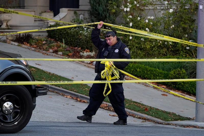 A police officer rolls out yellow tape near the home of Paul Pelosi, the husband of House Speaker Nancy Pelosi, in San Francisco.