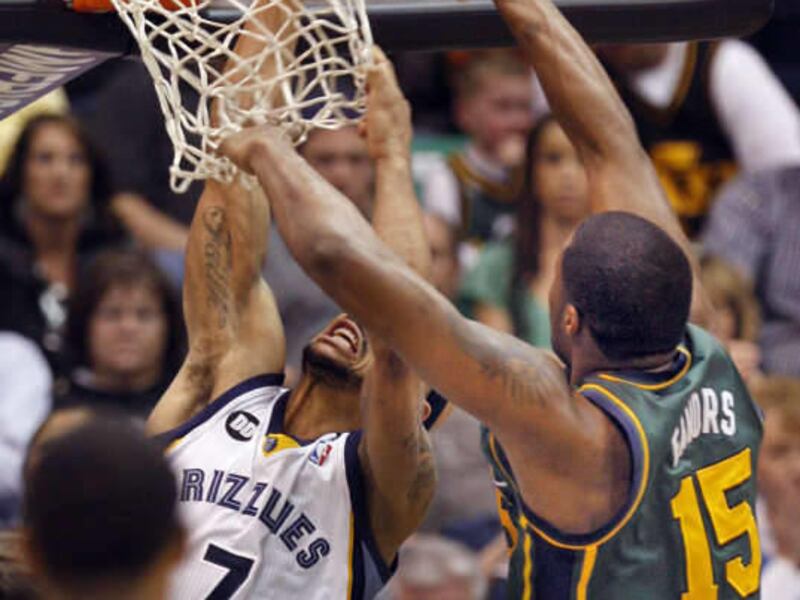 Memphis Grizzlies point guard Jerryd Bayless (7) grabs the net as he slips the ball past Utah Jazz power forward Derrick Favors (15) as the Utah Jazz defeat the Memphis Grizzlies 90-84 as they play NBA basketball Saturday, March 16, 2013, in Salt Lake Ci