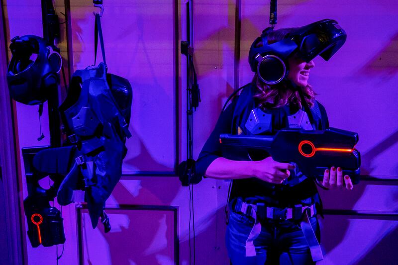 FILE - Lyndsey Besser demonstrates the equipment to the Ghostbusters Dimension experience at THE VOID in Lindon on Monday, April 3, 2017.