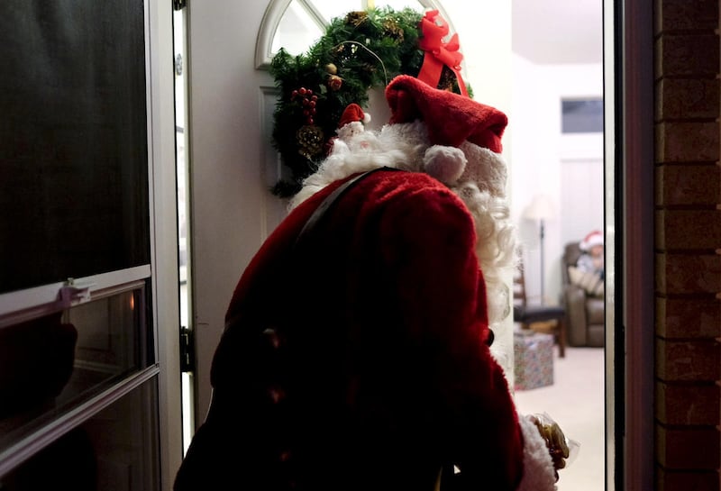 In this Friday, Dec. 9, 2016 photo, David Carter, dressed as Santa Claus, exits a Christmas party at the Quarnberg's home in Lindon, Utah. Carter has been dressing up as Santa for holiday parties the past 21 years. (Isaac Hale/The Daily Herald via AP)