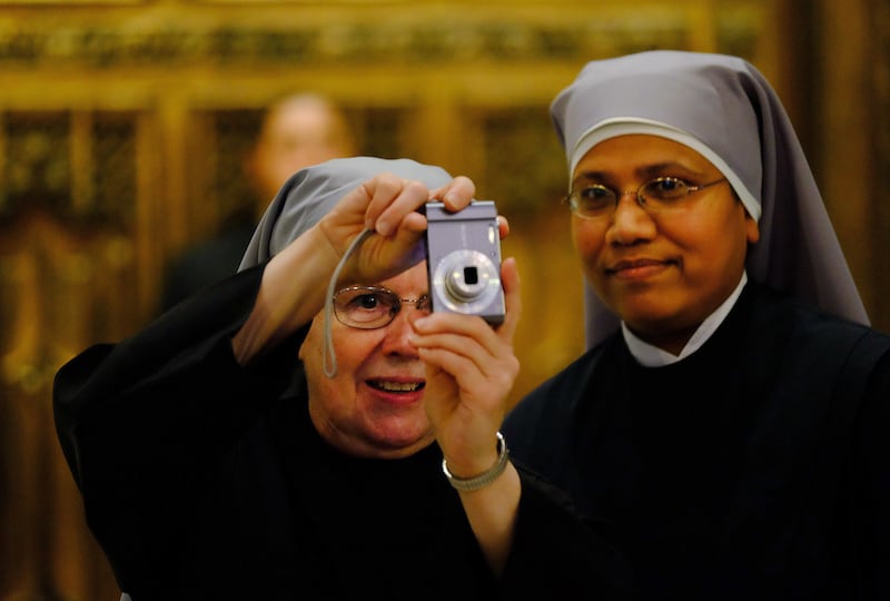 Sister Maureen takes a photo of the newly renovated interior with Sister Laurelliya, both of the Little Sisters of the Poor from Scranton, Pa., while waiting for Pope Francis to arrive Thursday, Sept. 24, 2015, at St. Patrick's Cathedral in New York. (Rob