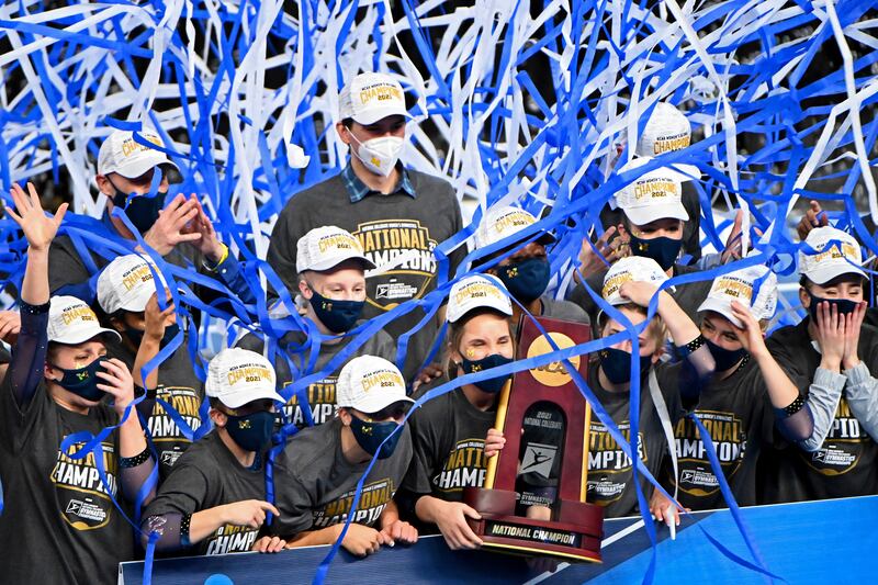 Michigan gymnasts celebrate with the national championship trophy.