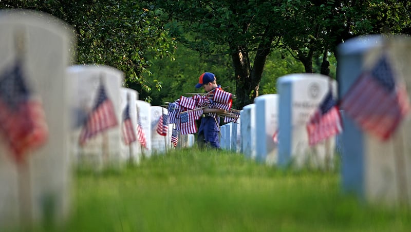 Tiger Scout Christian Pavlock, 7, carries American flags in honor of the Memorial Day holiday.