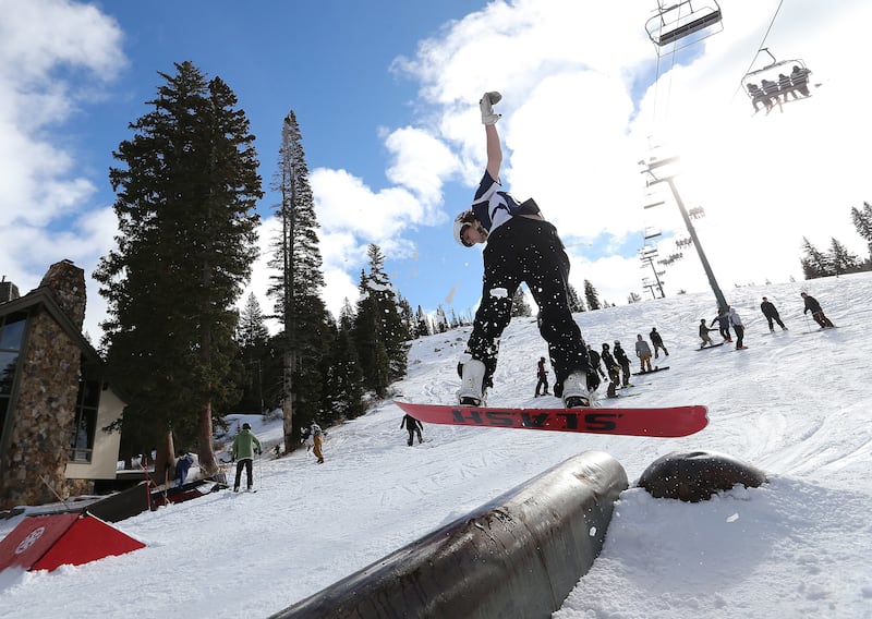 A snowboarder rides in one of Brighton Ski Resort's five terrain parks during opening day on Tuesday, Nov. 21, 2017.