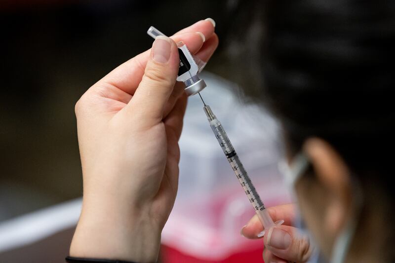 A nurse fills a syringe with a dose of the Pfizer-BioNTech COVID-19 vaccine.