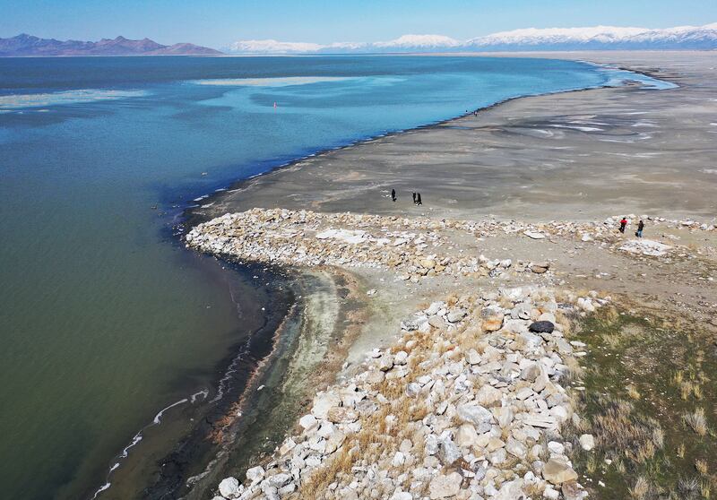 People walk on the beach of the Great Salt Lake in Salt Lake City on Friday, March 17, 2023.