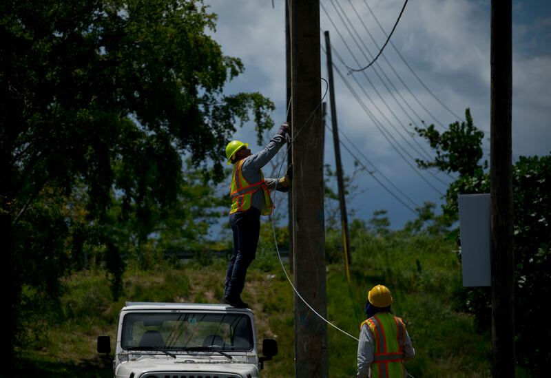 Workers of the electric repair brigade remove old cables from a post in San German, Puerto Rico, Wednesday, May 30, 2018. After an eight-month, $3.8 billion federal effort to try to end the longest blackout in United States history, officials say Puerto R