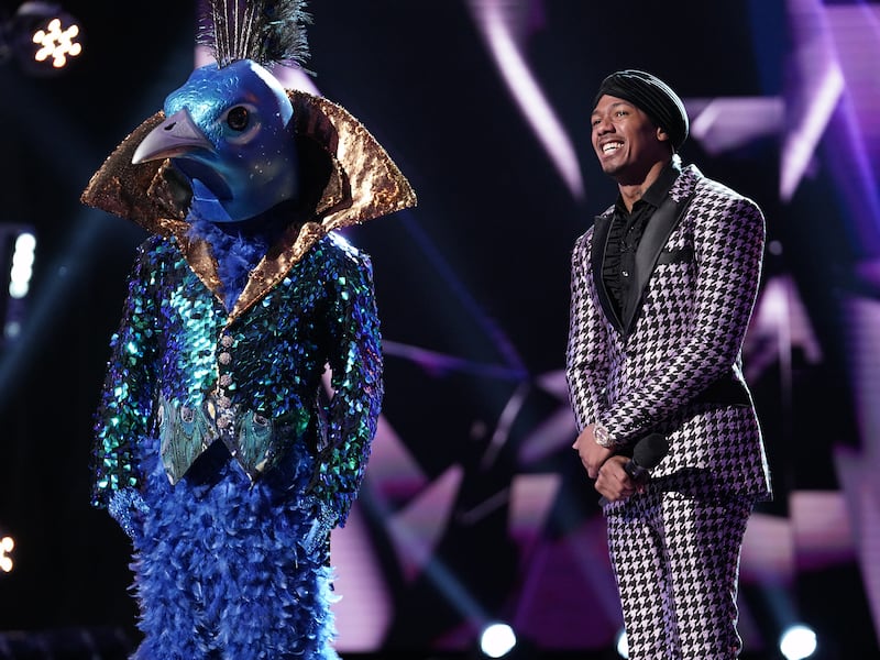 Peacock, left, and host Nick Cannon in the “Five Masks No More” episode of "The Masked Singer," which aired Wednesday, Jan. 16.