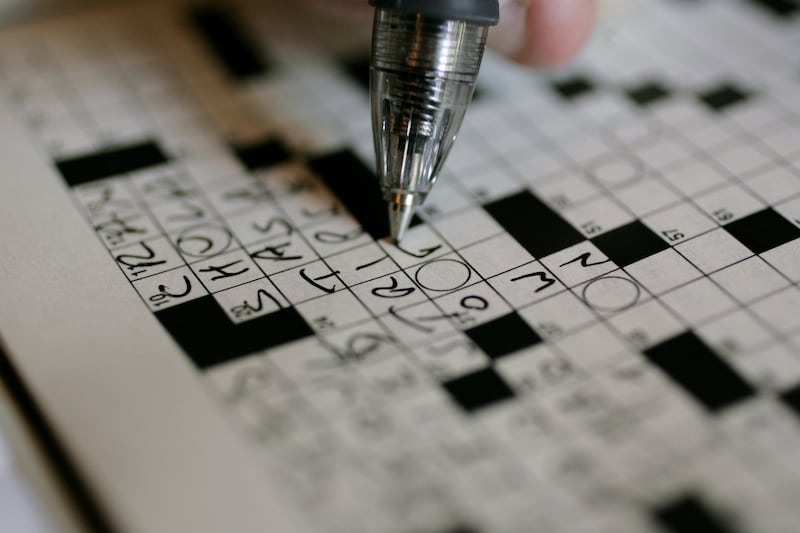 A puzzle fan works on the New York Times crossword puzzle in pen at the “Wordplay” brunch in Park City, Utah.