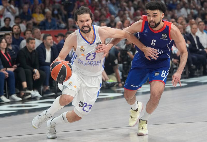 Anadolu Efes’ Elijah Bryant , wearing blue, guards Real Madrid’s Sergio Llull