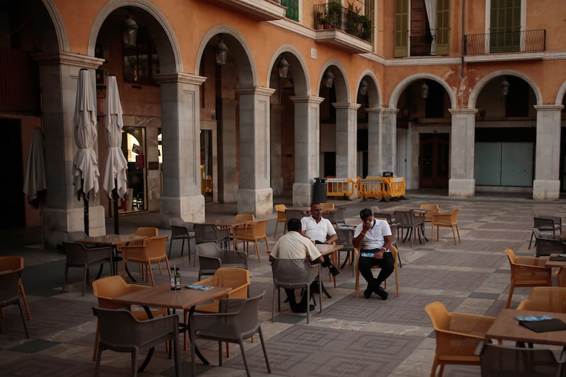 People sit in a nearly empty restaurant in the Balearic Islands capital of Palma de Mallorca, Spain, Wednesday, July 29, 2020. Concerns over a new wave of coronavirus infections brought on by returning vacationers are wreaking havoc across Spain’s tourism industry, particularly in the Balearic Islands following Britain’s effective ban on travel to the country.